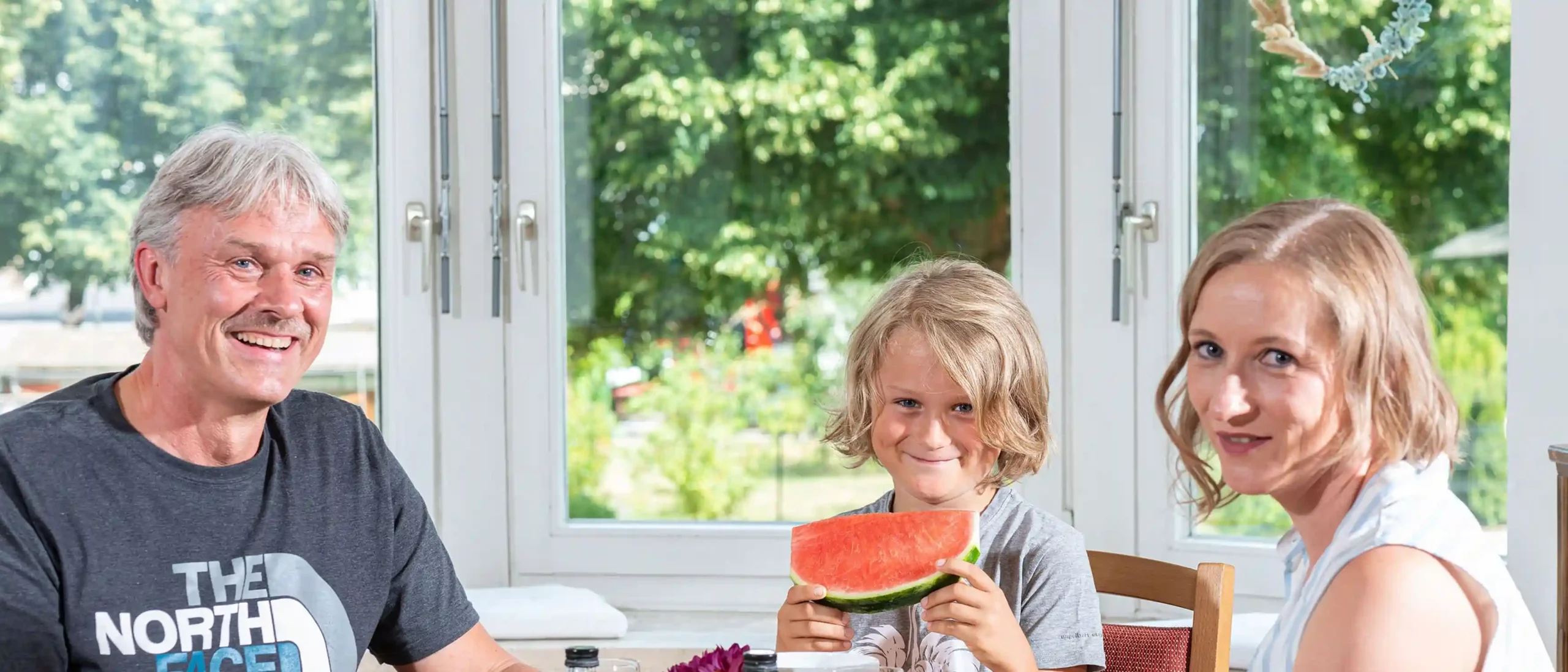 Eine Familie sitzt am Tisch und genießt gemeinsam ihr Frühstück.